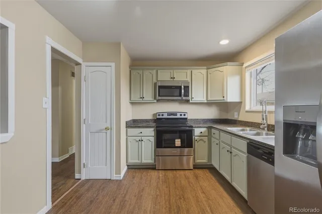 a kitchen with stainless steel appliances granite countertop a stove top oven a sink and cabinets