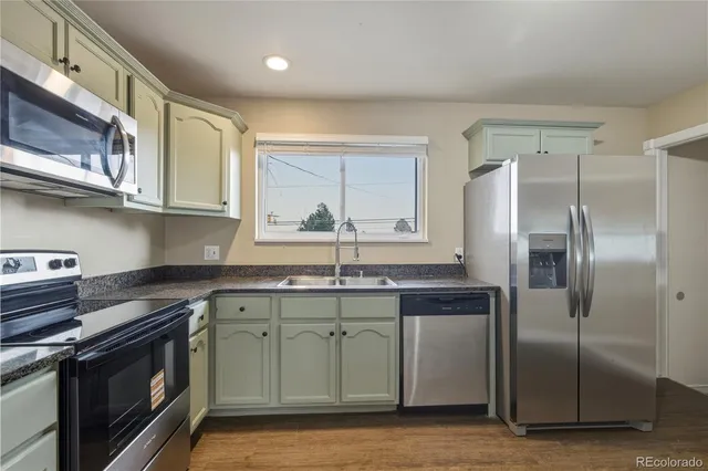 a kitchen with stainless steel appliances granite countertop a sink stove and refrigerator