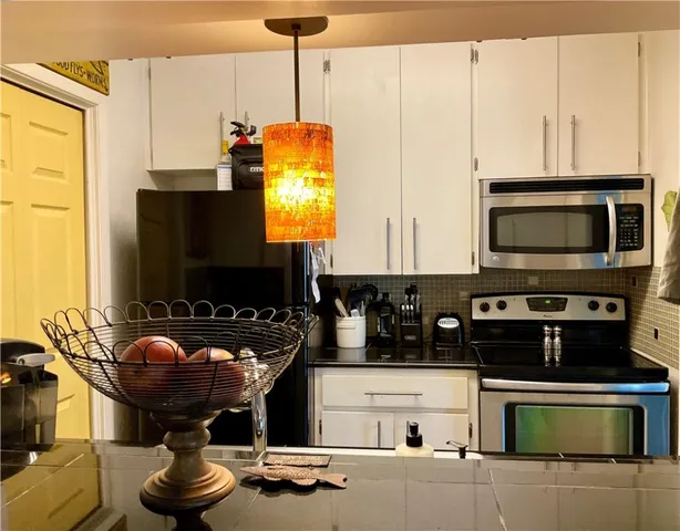 a kitchen with stainless steel appliances granite countertop a stove and a microwave