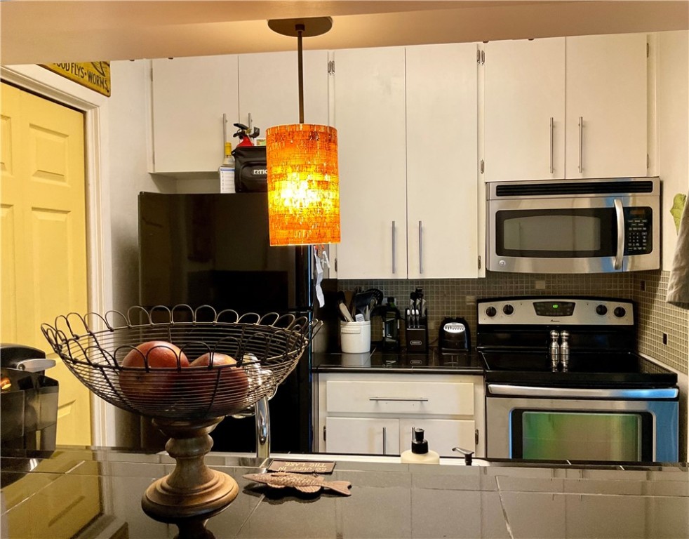 6718 Silvermine Drive, Unit 702 Austin, TX 78736 - Photo 5 of 19 a kitchen with stainless steel appliances granite countertop a stove and a microwave