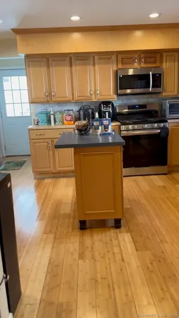 a kitchen with stainless steel appliances a stove a sink and a microwave