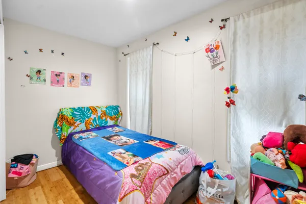 a bedroom with a bed and a wooden floor