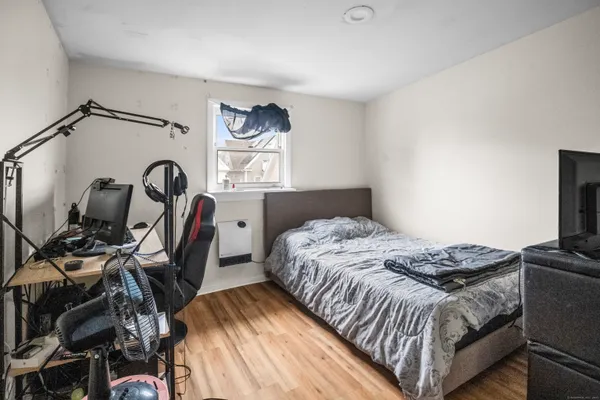 a bedroom with a bed and a flat tv screen on the dresser
