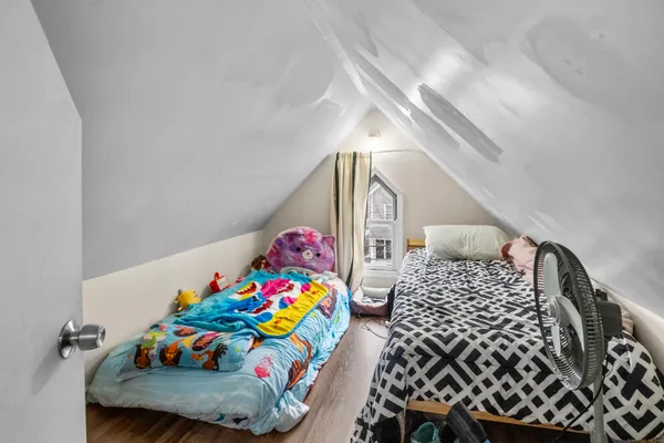 a bedroom with baby toys and wooden floor