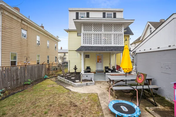 a front view of a house with swimming pool and furniture