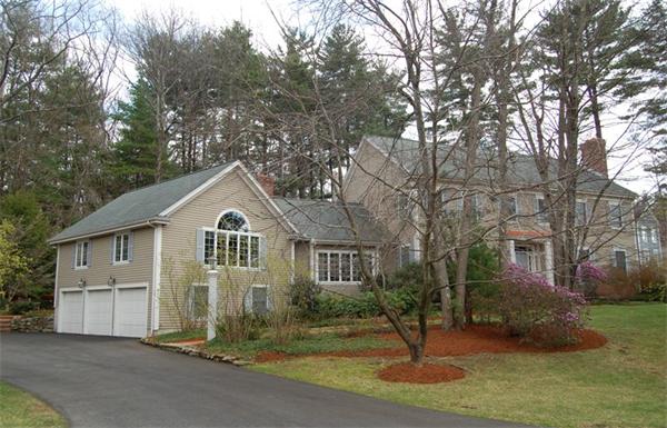 a front view of a house with garden and trees