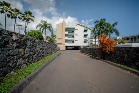 a view of a street with a building and bench in front of it