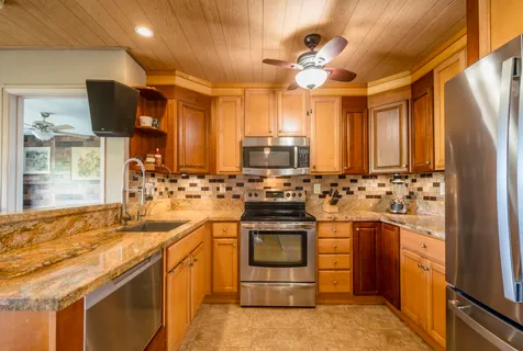 a kitchen with stainless steel appliances granite countertop a sink and cabinets