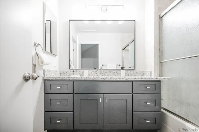a bathroom with a granite countertop sink vanity and mirror