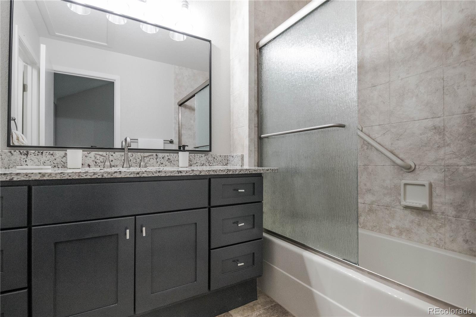 2920 South Racine Street Aurora, CO 80014 - Photo 16 of 36 a bathroom with a granite countertop sink and mirror