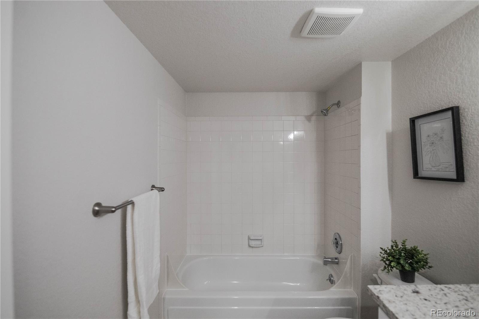 2920 South Racine Street Aurora, CO 80014 - Photo 21 of 36 a bathroom with a bathtub and shower