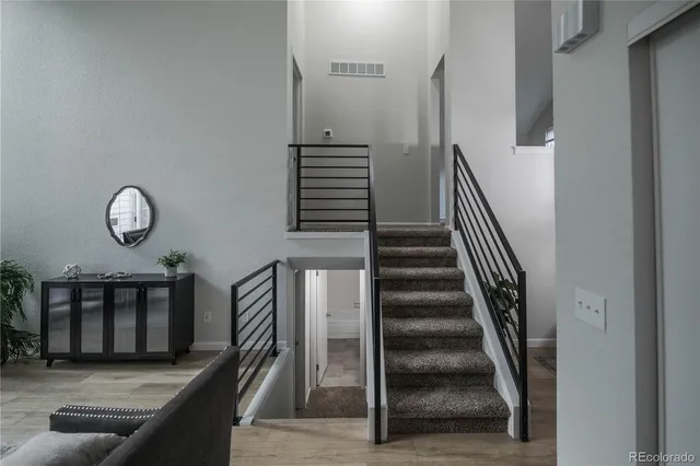 a view of a livingroom with wooden floor and stairs