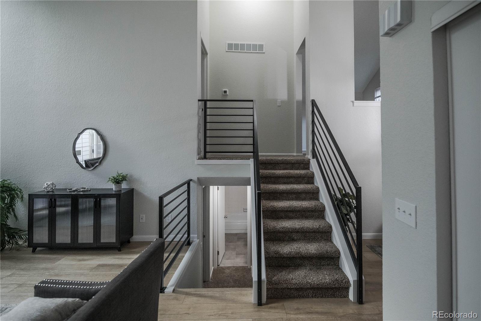 2920 South Racine Street Aurora, CO 80014 - Photo 3 of 36 a view of a livingroom with wooden floor and stairs