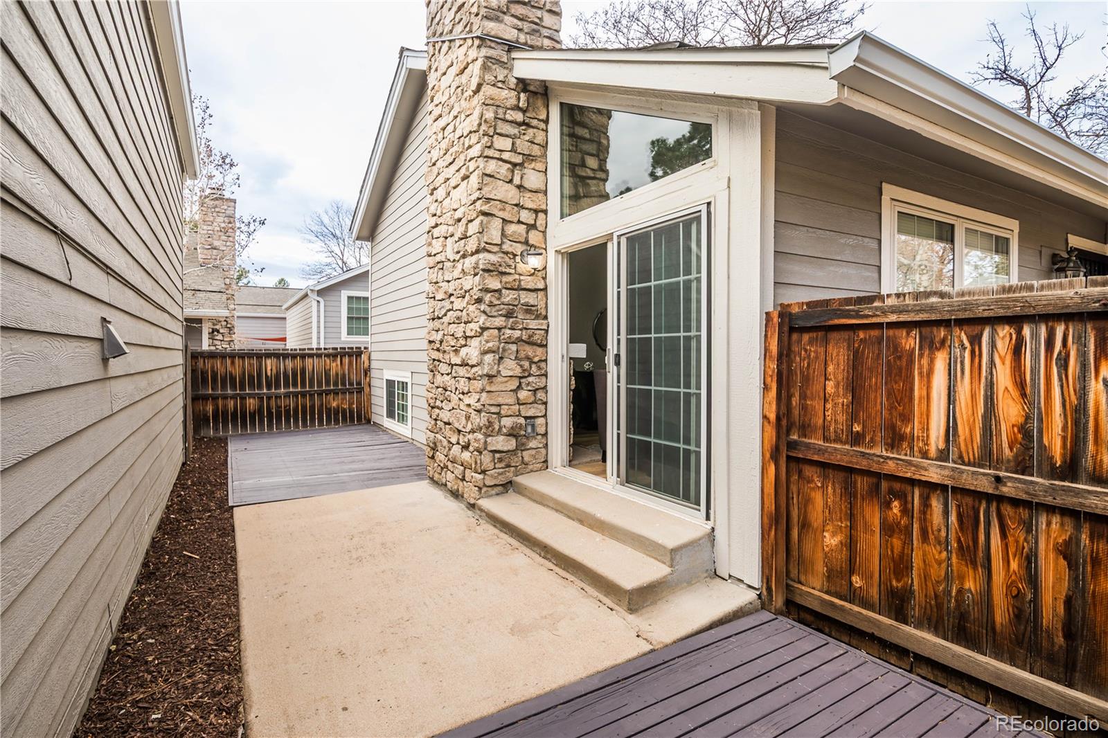 2920 South Racine Street Aurora, CO 80014 - Photo 32 of 36 a view of a balcony with wooden floor and fence and a floor to ceiling window