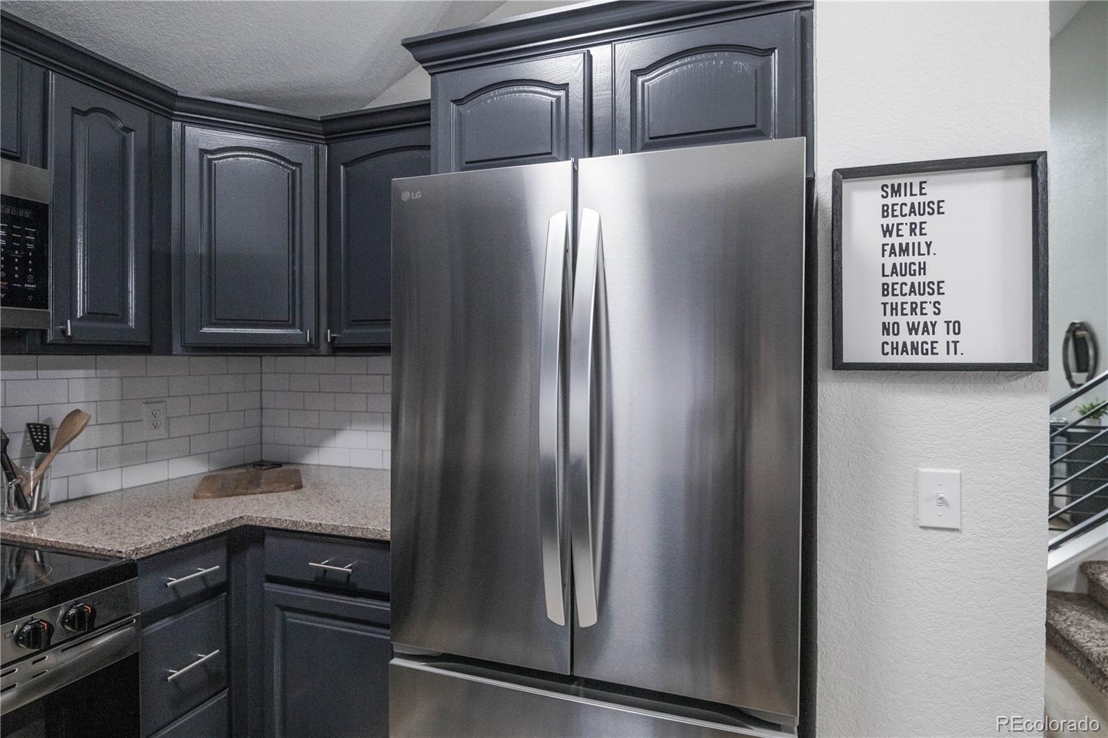 2920 South Racine Street Aurora, CO 80014 - Photo 10 of 36 a kitchen with metallic refrigerator and sink