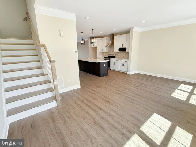 a view of a kitchen with wooden floor and electronic appliances