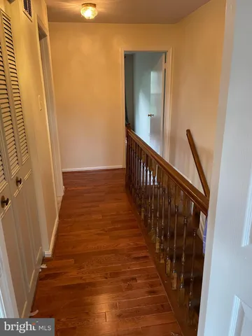 a view of a hallway with wooden floor and staircase