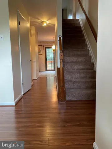 a view of a hallway with wooden floor and staircase