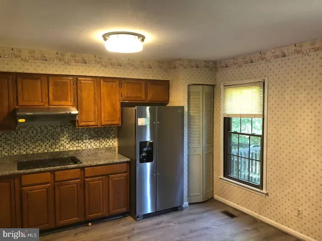 a kitchen with stainless steel appliances granite countertop a refrigerator and cabinets