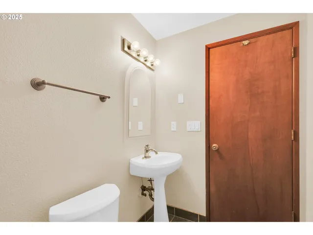 a bathroom with a sink a toilet and a mirror