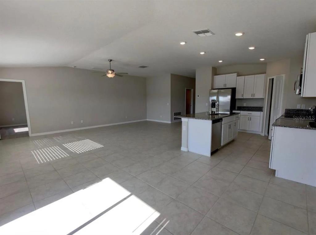 31699 Sun Kettle Loop Wesley Chapel, FL 33545 - Photo 2 of 18 a view of kitchen with refrigerator and white cabinets