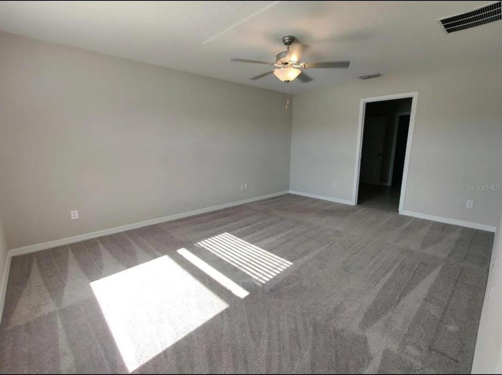 31699 Sun Kettle Loop Wesley Chapel, FL 33545 - Photo 4 of 18 a view of an empty room with wooden floor