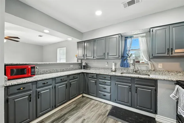 a kitchen with stainless steel appliances granite countertop a sink stove and cabinets