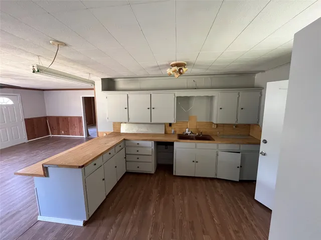 a kitchen with a sink cabinets and wooden floor