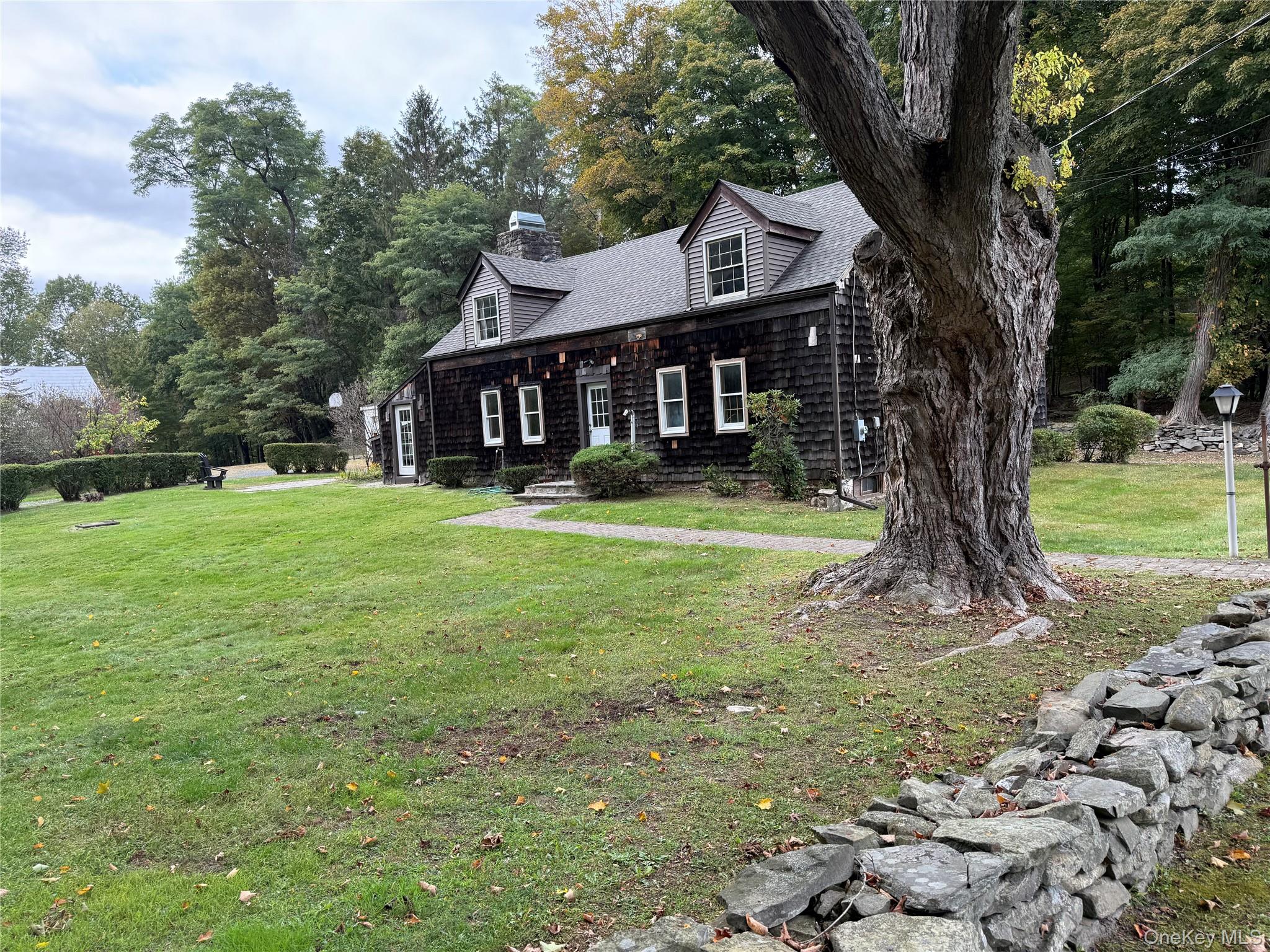 241 White Bridge Road Middletown, NY 10940 - Photo 5 of 29 New england style home featuring a front yard, a chimney, view of wooded area, and roof with shingles