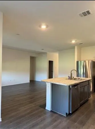 a view of kitchen with stainless steel appliances a sink and wooden floor