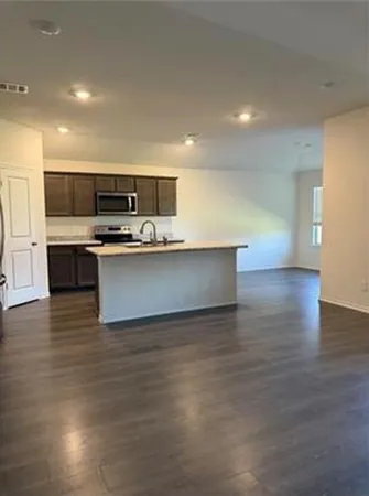 a kitchen with stainless steel appliances granite countertop a sink and a stove with wooden floor