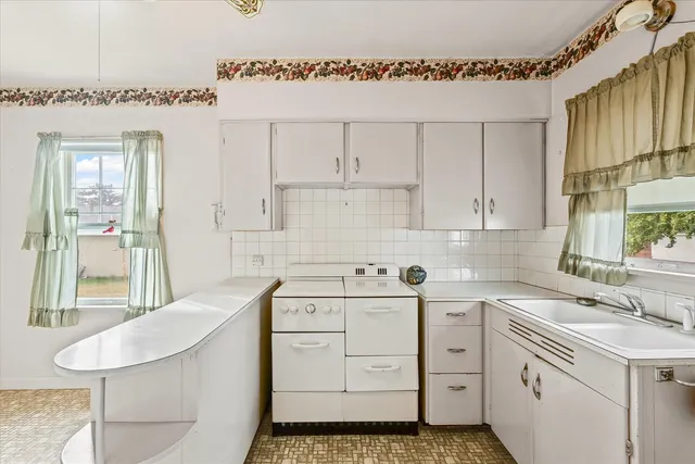 a kitchen that has a sink and a stove in it