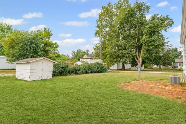 a view of a house with a big yard and large trees