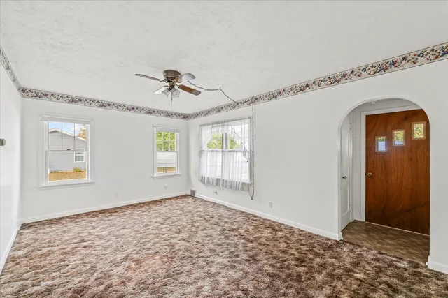 a view of a livingroom with wooden floor and a ceiling fan
