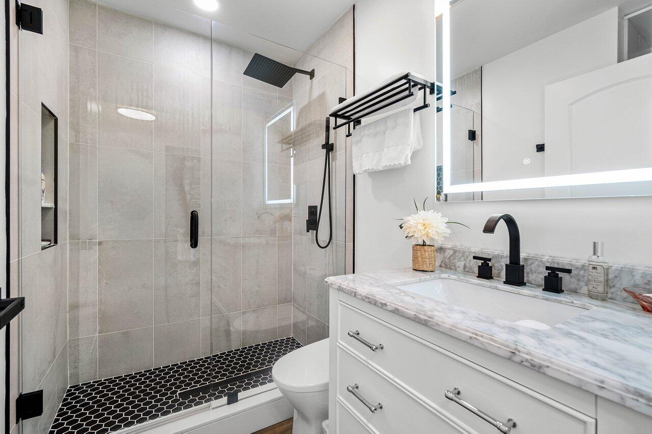 8195 Mooring Circle Boynton Beach, FL 33472 - Photo 17 of 28 a bathroom with a granite countertop sink a toilet and shower