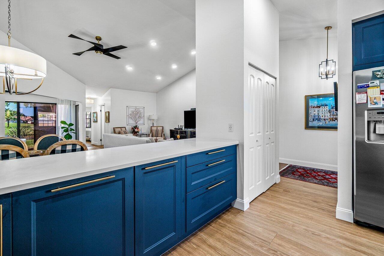 8195 Mooring Circle Boynton Beach, FL 33472 - Photo 9 of 28 a kitchen with stainless steel appliances sink cabinets and wooden floor