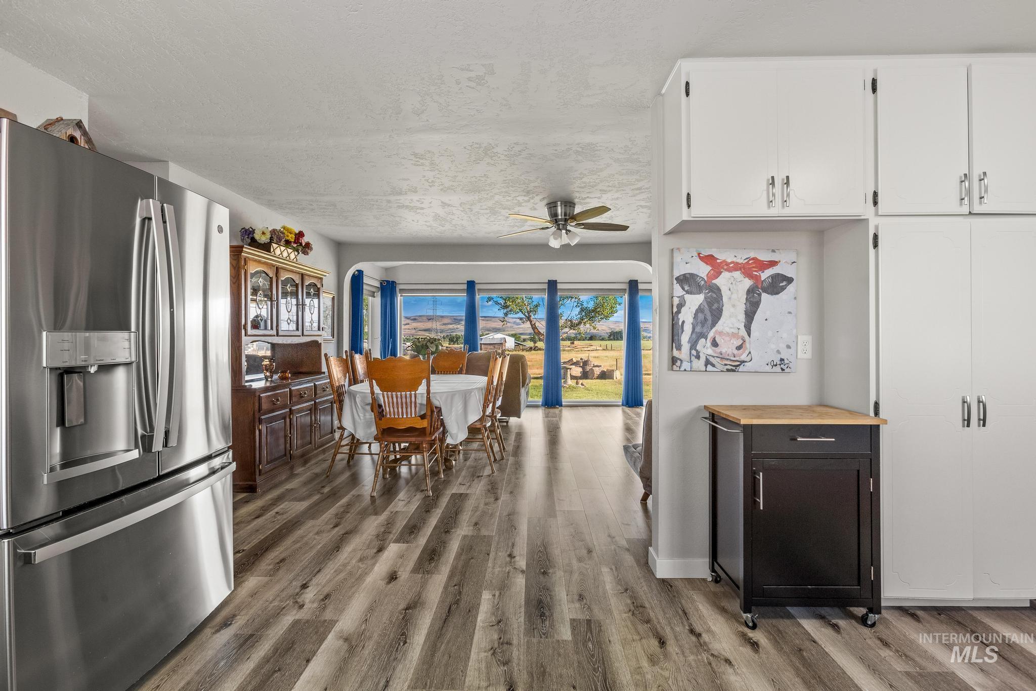 2208 Keithley Creek Road Midvale, ID 83645 - Photo 17 of 45 Kitchen with stainless steel refrigerator with ice dispenser, wood finished floors, white cabinets, ceiling fan, and a textured ceiling