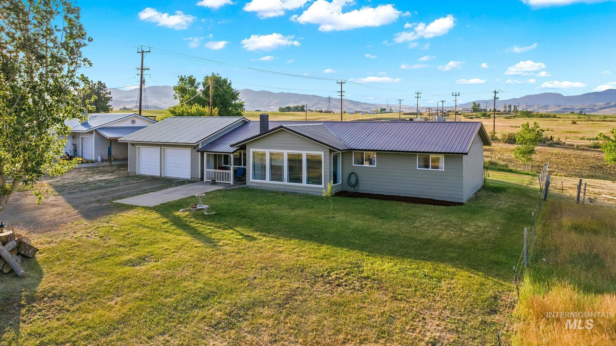 2208 Keithley Creek Road Midvale, ID 83645 - Photo 2 of 45 Rear view of house featuring a metal roof, a mountain view, driveway, and a garage