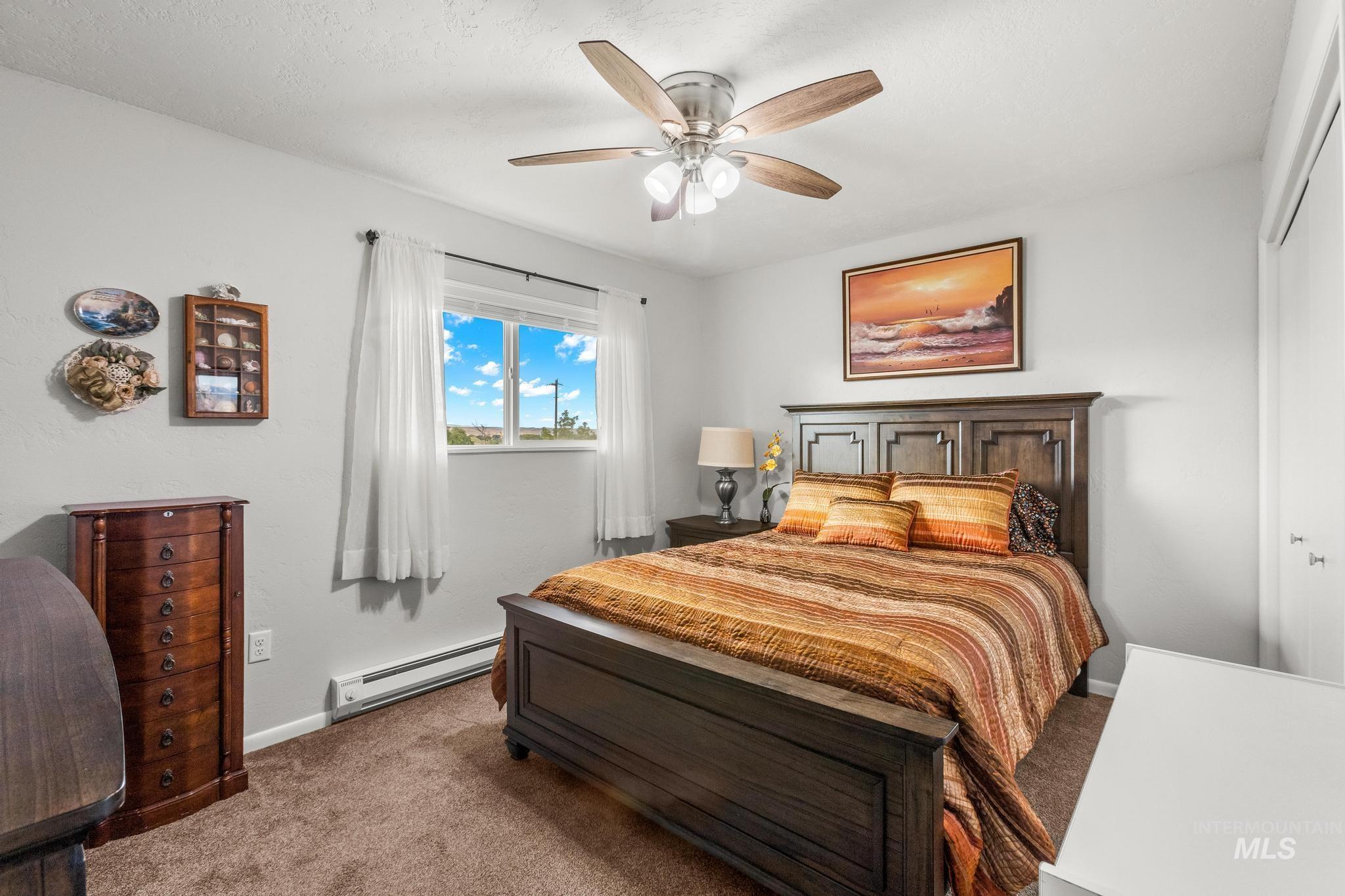 2208 Keithley Creek Road Midvale, ID 83645 - Photo 24 of 45 Bedroom with a baseboard heating unit, carpet, and a ceiling fan