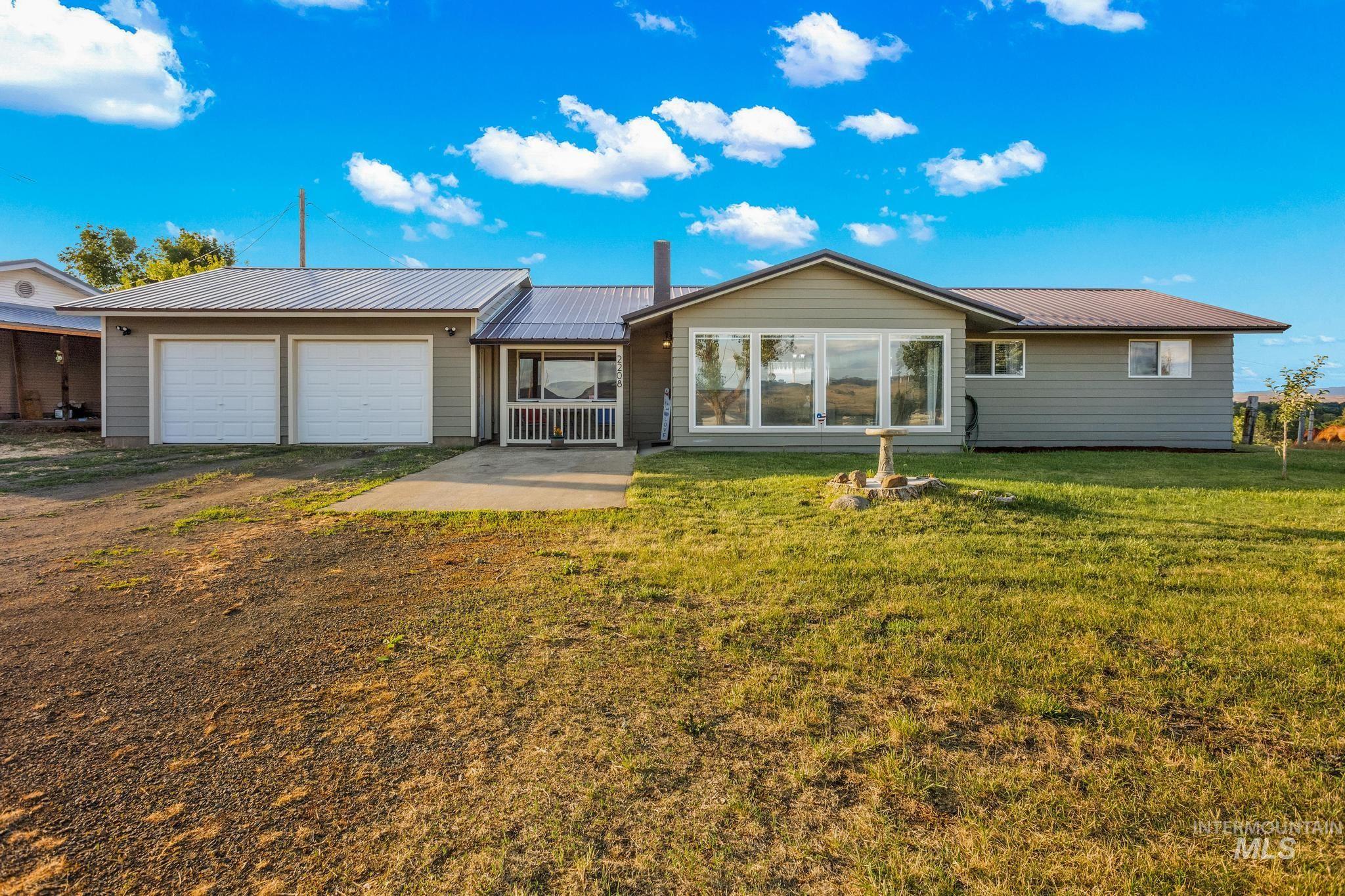 2208 Keithley Creek Road Midvale, ID 83645 - Photo 5 of 45 Rear view of property with an attached garage, a metal roof, asphalt driveway, and a lawn