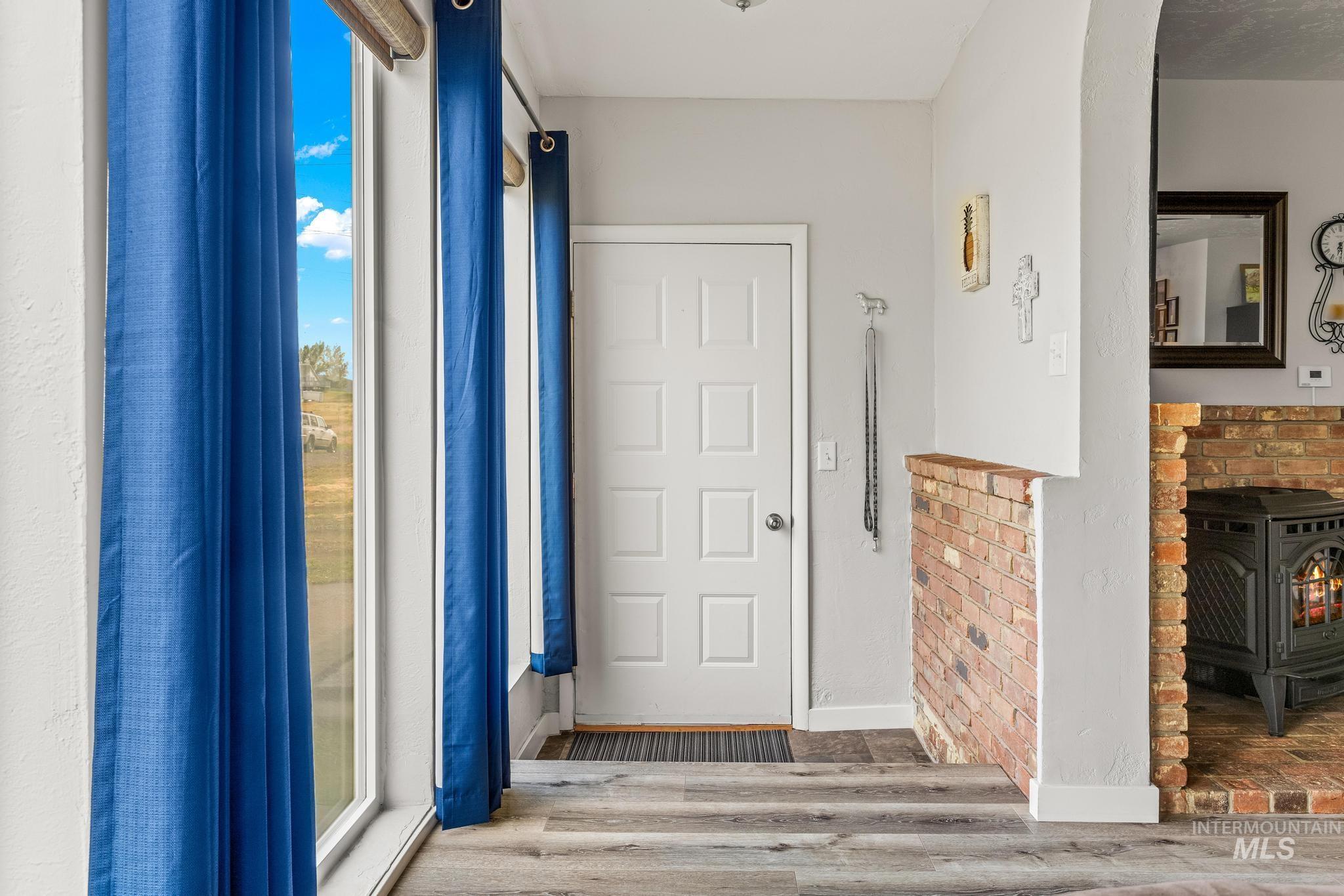 2208 Keithley Creek Road Midvale, ID 83645 - Photo 6 of 45 Foyer entrance with a wood stove, arched walkways, and wood finished floors