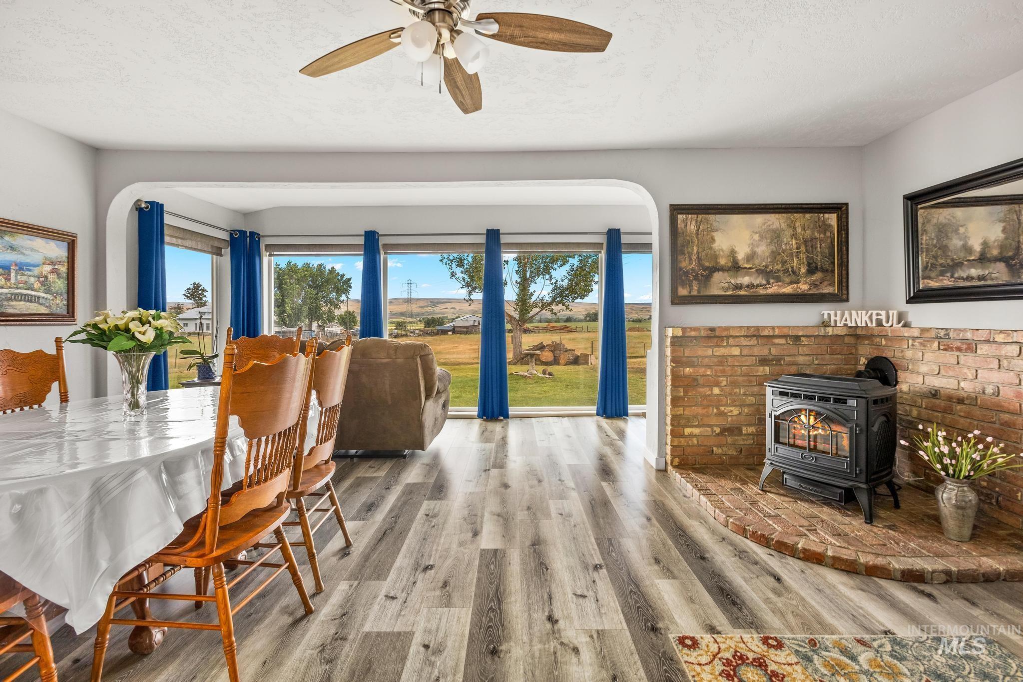 2208 Keithley Creek Road Midvale, ID 83645 - Photo 7 of 45 Dining room with a wood stove, wood finished floors, ceiling fan, a textured ceiling, and arched walkways