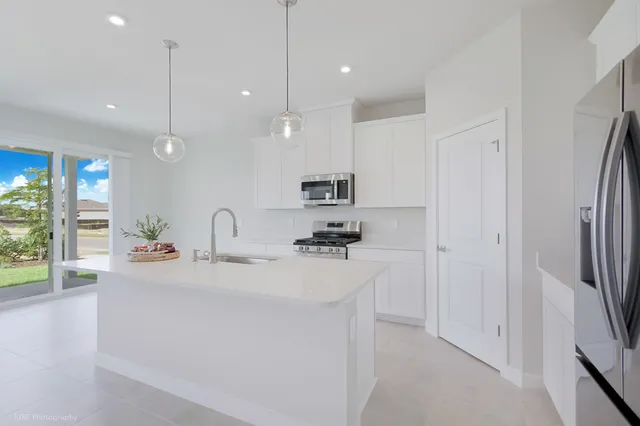 a kitchen with kitchen island a sink stainless steel appliances and window