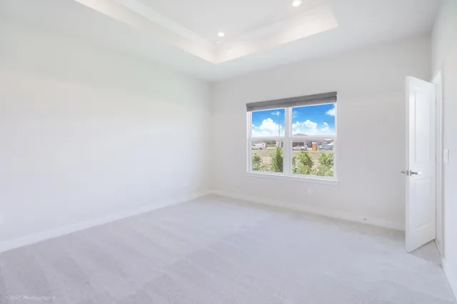 an empty room with windows and mirror