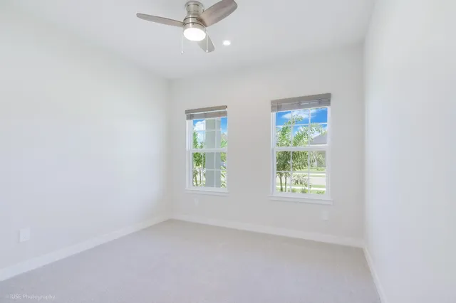an empty room with a window and a fan
