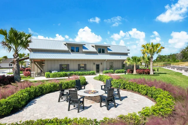 a view of a patio with couches chairs potted plants and a big yard