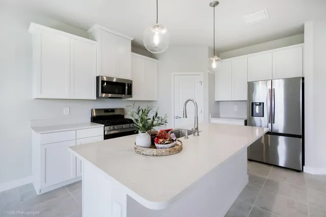a kitchen with stainless steel appliances granite countertop a sink dishwasher a refrigerator and a stove