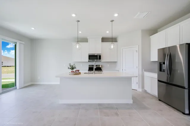 a view of a kitchen with stainless steel appliances granite countertop a refrigerator and a sink