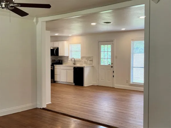 a view of a kitchen with wooden floor and electronic appliances