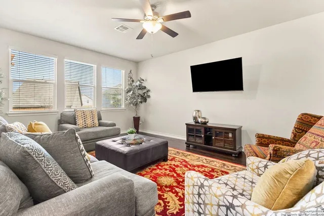 a living room with furniture a flat screen tv and a window